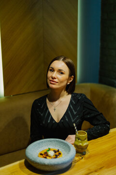 Beautiful young woman sitting at a table in a cafe