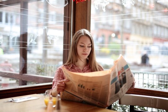 young woman reads a newspaper