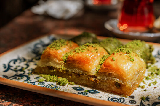 Traditional Turkish pistachio baklava served on a table. The sweet dessert features layers of thin filo pastry filled with crushed pistachios and soaked in syrup, cut into diamond-shaped pieces.