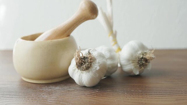 garlic mortar and pestle with fresh garlic cloves close up