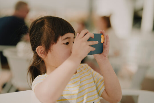 Young girl photographing with a smartphone held up to her face in Madeira