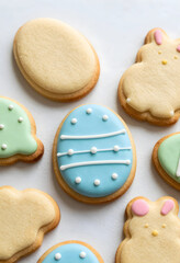 Fototapeta premium Easter celebration and spring holiday baking, decorated sugar cookies shaped like eggs and bunnies with pastel icing on a clean white background