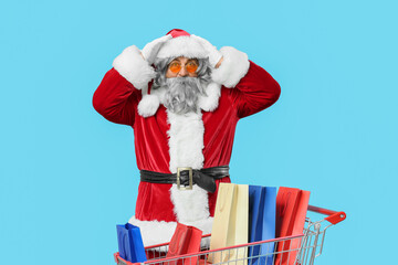 Holiday shopping stress, stressed Santa Claus with shopping bags in a cart feeling overwhelmed by Christmas consumerism and seasonal retail pressure © Pixel-Shot