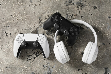 Gaming culture and entertainment, modern video game controllers and wireless headphones on a textured concrete background for esports and leisure © Pixel-Shot