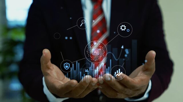 Businessman in a dark suit holding a glowing holographic artificial intelligence icon with digital charts and network connections animation above his open hands.