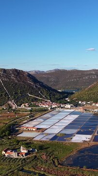Ston, Croatia, aerial drone footage of the historic salt pans, medieval walls, mountains and town