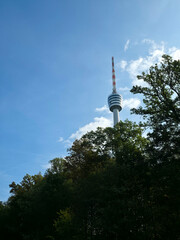 famous stuttgart tv tower stands elegantly beyond lush woodland trees against clear blue heavens creating an iconic german travel scene © Simon Dux Media