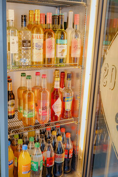 Bad Hersfeld, Germany, 08.15.26. organized refrigerator filled with soft drinks and alcohol in a modern interior setting with white and clear glass shelves, close-up view of the beverage bottles.