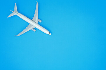 White airplane model flying across blue background showing travel flight concept with peaceful optimism and adventure symbolism © Nim9ty  Pics