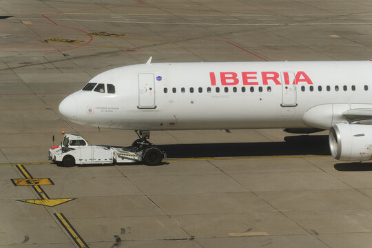 Geneva, Switzerland - september 19, 2026: sign and logo on An Iberia Airbus commercial airliner hooked to a pushback tractor at the gate bridge at Geneva Airport, Switzerland.