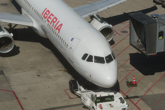 Geneva, Switzerland - september 19, 2026: sign and logo on An Iberia Airbus commercial airliner hooked to a pushback tractor at the gate bridge at Geneva Airport, Switzerland.