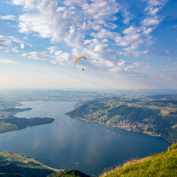 Paraglider flying above Lake Zug from the summit of Mount Rigi Switzerland