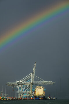 Rainbow over a cargo ship at Rotterdam harbour container terminal