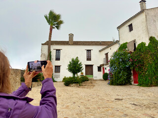 Senior female tourist taking smartphone photo of white Spanish village © Paolo Corazza