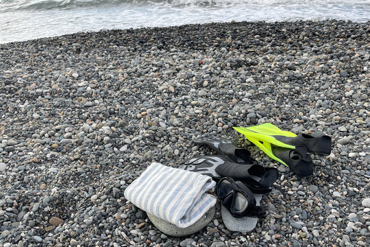 flippers and mask for diving near the towel on the beach