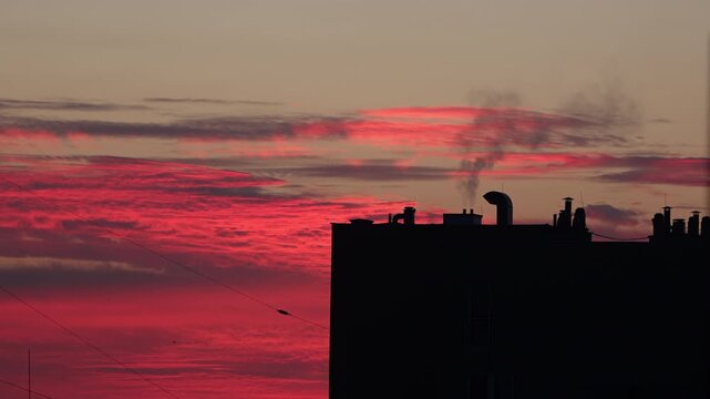Chimneys of a multi-family residential building emitting black smoke from gas heating.