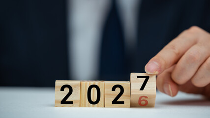 비즈니스 콘셉트에서 연도를 2026년에서 2027년으로 바꾸기 위해 손이 큐브를 뒤집는 모습 © JYPIX