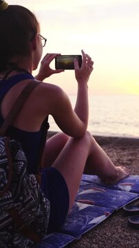 Dolly slide around person at beach take photo of sunset