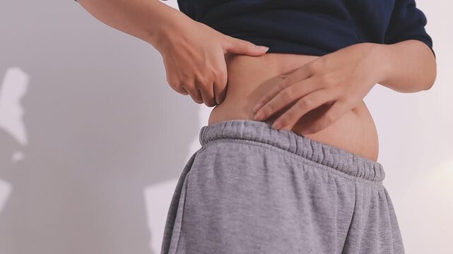 Overweight woman body with hands touching belly fat