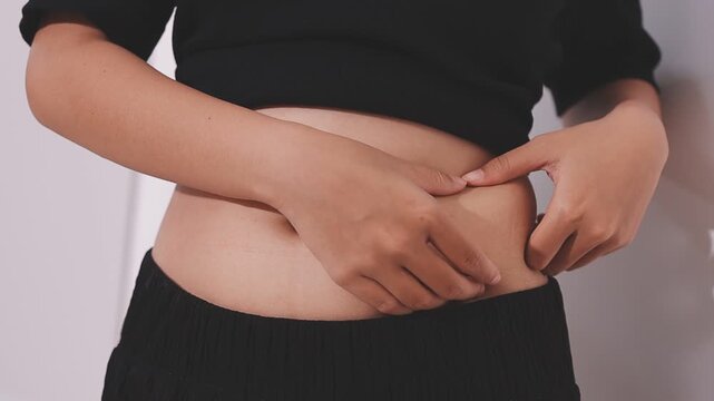 Overweight woman body with hands touching belly fat