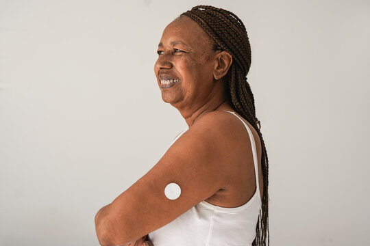 Happy senior african woman with diabetes patch on her arm - Healthcare, medicine and people disease concept - Copy space