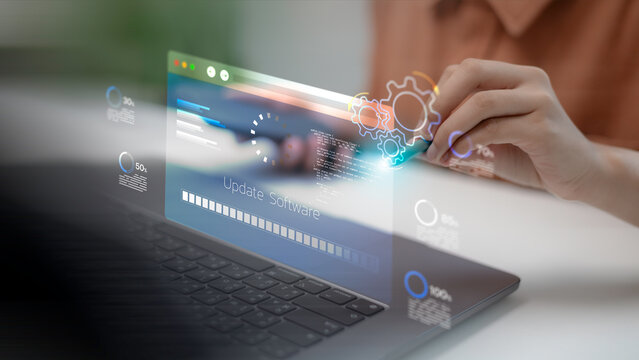 A software developer using a laptop and touching a virtual screen for software update progress, system maintenance installation, operating system upgrade, and modern digital data processing.