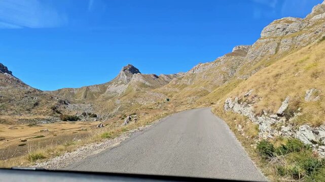 Horizontal slow motion b-roll of driving on an empty asphalt mountain road on the famous Sedlo pass in Montenegro