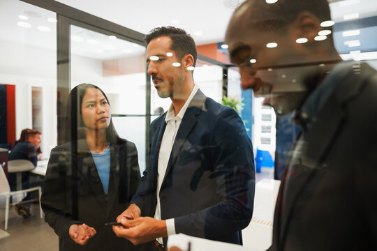 Multiracial colleagues working inside business office with glass walls - Entrepreneurs people sharing ideas at teamwork meeting - Brainstorming concept - Main focus on asian girl face - UGC content