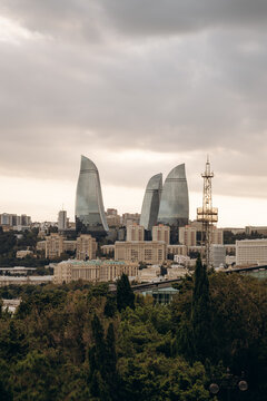 Baku, Azerbaijan cityscape featuring the iconic Flame Towers and modern urban architecture under a dramatic cloudy sky
