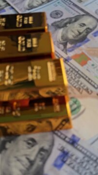 Gold bars stacked on money create a striking display of wealth and
