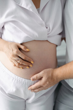 Pregnant woman and partner holding her belly at home, expecting parents, pregnancy support, family bonding, maternity lifestyle.