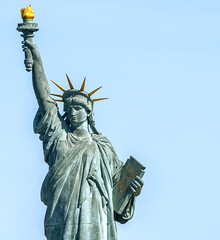 Statue of Liberty on Ile aux Cygnes island against clear blue sky in Paris © Gun