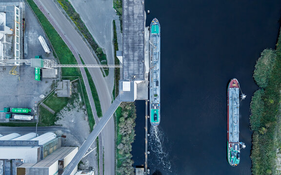 Aerial view of Tata Steel industrial complex with cargo ships docked in the canal, industrial buildings, and surrounding infrastructure in Velsen-Noord, Noord-Holland, Netherlands.