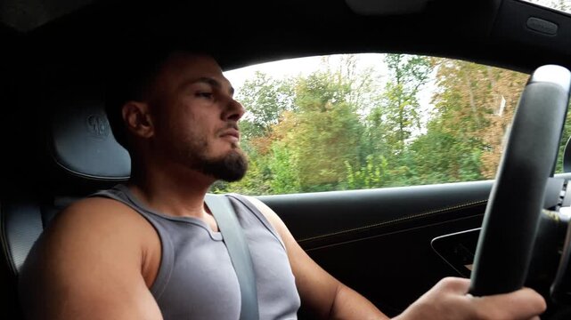 Focused Young Athletic Man Driving Luxury Car on Highway Road Trip Transport and Driver Lifestyle Concept