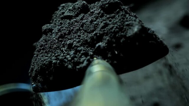POV camera attached to a shovel handle while digging soil and throwing it into a bucket in total darkness. The scene evokes the unsettling feeling of secretly digging a grave at night.
