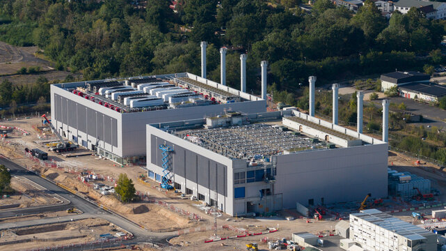 Aerial view of the Data4 Hanau data center facility, featuring large industrial buildings with rooftop cooling units and exhaust stacks in Hanau, Hessen, Germany.