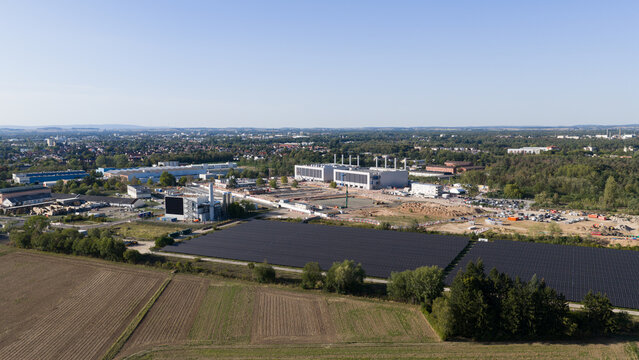 Aerial view of the Data4 Hanau data center facility, surrounded by solar panel arrays, industrial buildings, and agricultural fields in Hanau, Hessen, Germany.