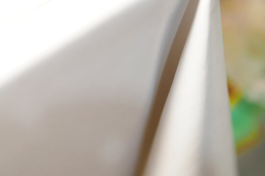 close-up view of a folded white fabric cloth with soft light and shadows