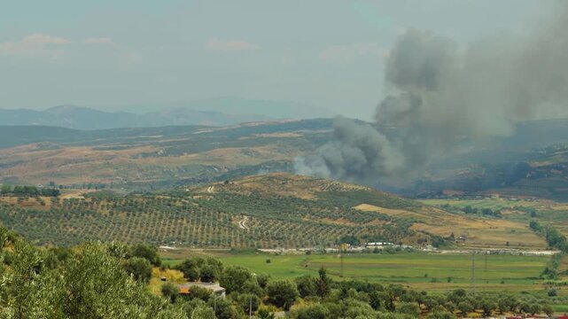 Heavy Smoke Rising From Wildfire Burning Hillside Covered With Olive Trees And Fields