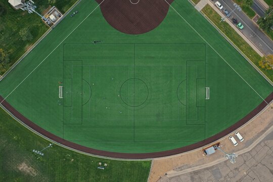 Aerial view of a soccer field with green artificial turf, white markings, and surrounding paved areas in Greeley, Colorado, United States.