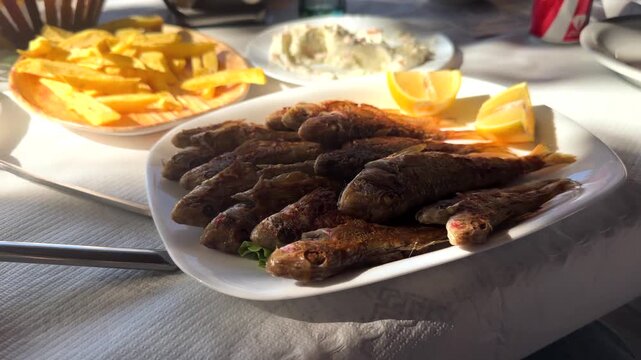 Fried Fish Served On Plate With Lemon Slices And French Fries