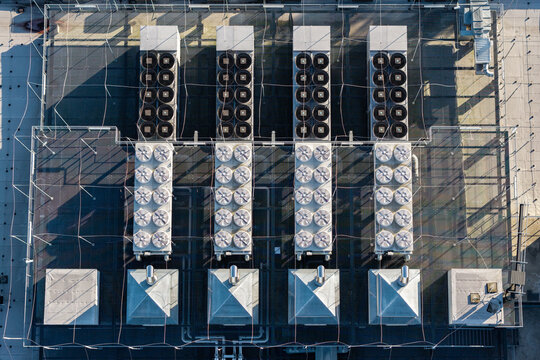 Aerial view of a data center rooftop featuring rows of industrial cooling fans, HVAC units, and ventilation systems in Warszawa, Wojewodztwo mazowieckie, Poland.