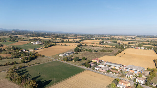 Aerial view of rural landscape with agricultural fields, scattered farm buildings, and local roads in Castelnuovo Fogliani, Emilia-Romagna, Italy.