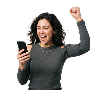 Excited young woman celebrating incredible victory while looking at her smartphone screen indoors