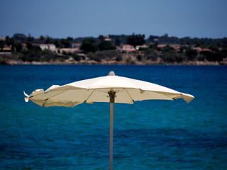 White Beach Umbrella Against Blue Mediterranean Sea in Sicily © Izanbar photos