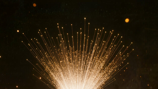 Golden fireworks bursting upward across dark night sky with glowing sparks, long exposure showing radiant trails and falling embers, conceptual celebration festival and new year festivity concept