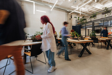Busy modern coworking office with people moving around