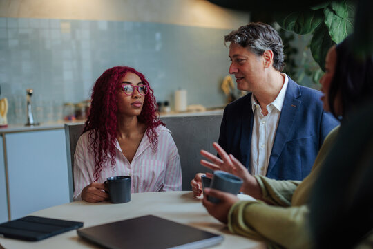 Business colleagues collaborating during a coffee break meeting