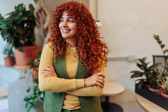 Confident young woman with red curly hair smiling