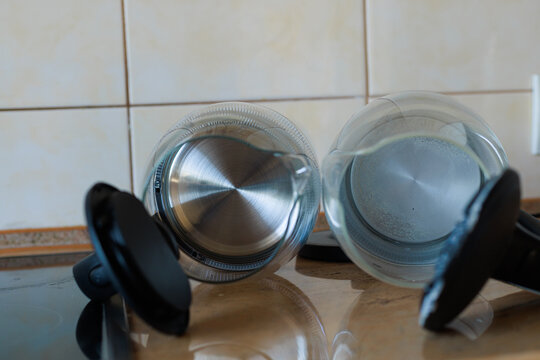 Top view of two glass electric kettles, one with limescale buildup and one clean without scale. The comparison shows hard water effects and the importance of regular descaling.
